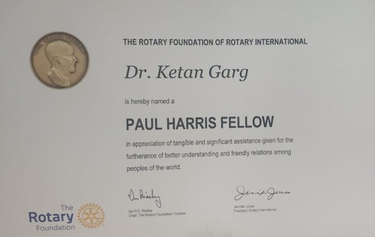 A close-up of a white certificate from The Rotary Foundation of Rotary International naming "Dr. Ketan Garg" a "PAUL HARRIS FELLOW" with signatures and the Rotary logo.